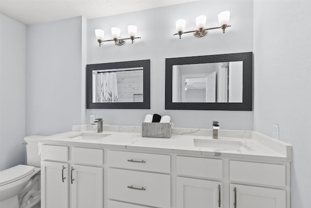 bathroom with a sink, toilet, a shower with shower curtain, and double vanity