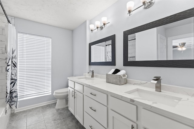 full bathroom featuring a sink, a textured ceiling, double vanity, and toilet