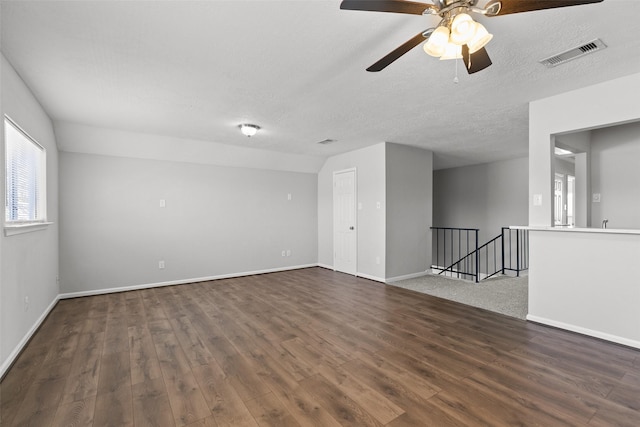 empty room featuring visible vents, baseboards, a textured ceiling, and wood finished floors