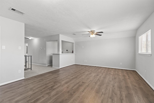 unfurnished living room featuring wood finished floors, baseboards, visible vents, ceiling fan, and a textured ceiling