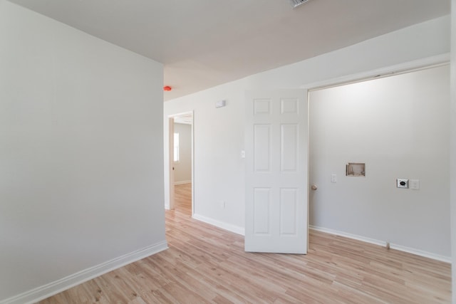 spare room with baseboards and light wood-style flooring