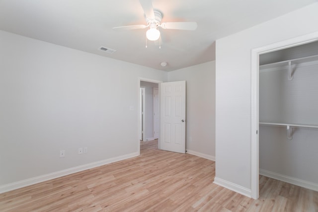 unfurnished bedroom with baseboards, visible vents, light wood-style flooring, ceiling fan, and a closet