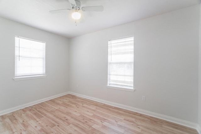 unfurnished room featuring plenty of natural light, baseboards, light wood-style floors, and ceiling fan