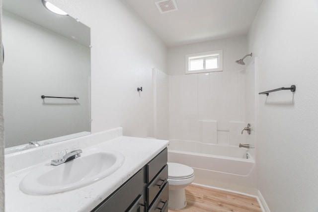 bathroom with visible vents, toilet, wood finished floors, washtub / shower combination, and vanity