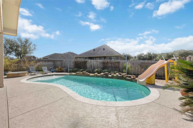 view of swimming pool featuring a patio area, a fenced in pool, a water slide, and a fenced backyard