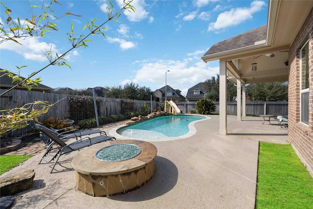 view of pool featuring a fenced in pool, a water slide, an outdoor fire pit, a fenced backyard, and a patio area