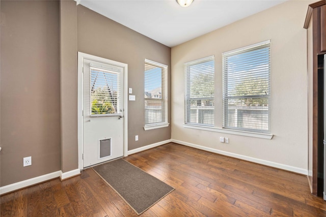 foyer with dark wood-type flooring and baseboards