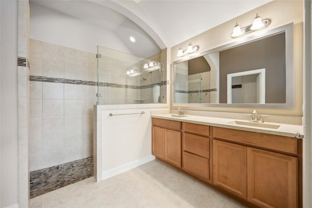 bathroom featuring double vanity, vaulted ceiling, walk in shower, and a sink