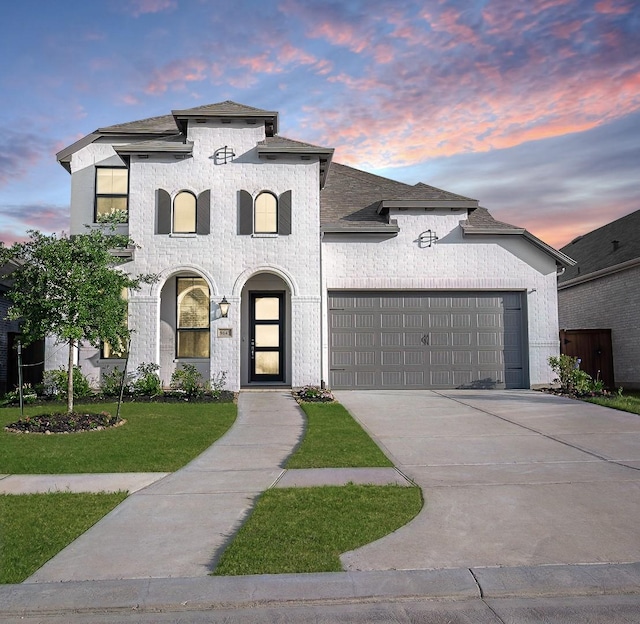 9647 Wright Dr, Manvel, TX 77578 - french country home featuring an attached garage, a front lawn, driveway, and a shingled roof