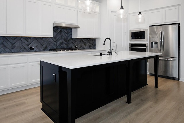 9647 Wright Dr, Manvel, TX 77578 - kitchen with stainless steel appliances, decorative backsplash, light wood-type flooring, light countertops, and pendant lighting