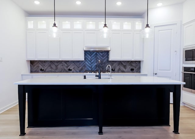 9647 Wright Dr, Manvel, TX 77578 - kitchen with stainless steel appliances, light countertops, decorative backsplash, a center island with sink, and recessed lighting