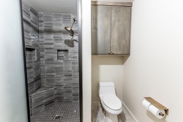 full bath featuring toilet, baseboards, and a stall shower