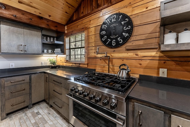 kitchen featuring open shelves, high end stainless steel range oven, dark countertops, wood walls, and lofted ceiling