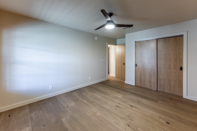 unfurnished bedroom with a closet, visible vents, light wood-type flooring, and baseboards