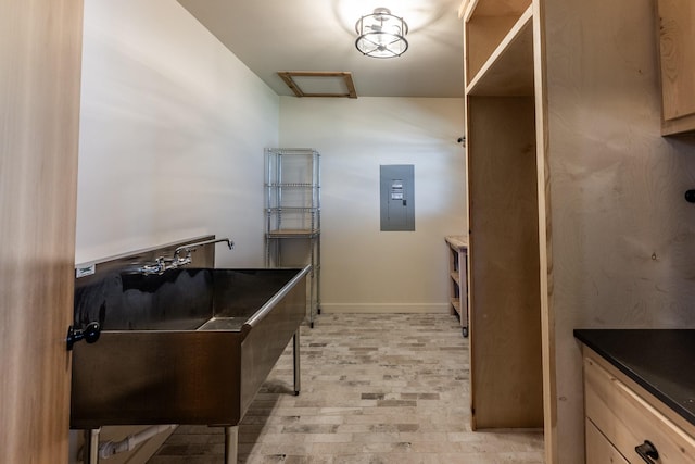 kitchen with a sink, baseboards, and dark countertops