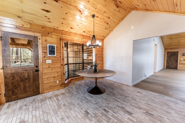 foyer with an inviting chandelier, wooden walls, wood ceiling, and high vaulted ceiling