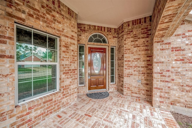 doorway to property featuring brick siding