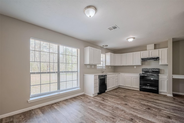 kitchen featuring visible vents, black appliances, under cabinet range hood, wood finished floors, and white cabinetry