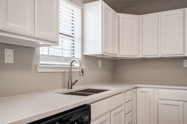 kitchen with white cabinets, dishwasher, light countertops, and a sink