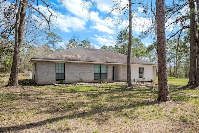 view of front facade featuring brick siding and a front lawn