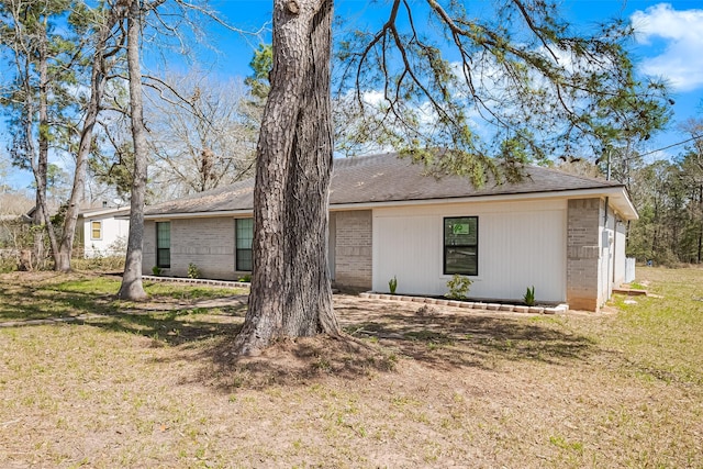 view of front of house featuring brick siding and a front yard