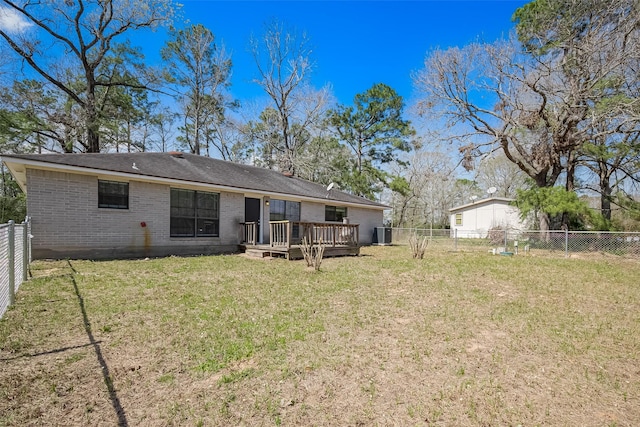 back of property featuring a deck, a yard, a fenced backyard, and brick siding