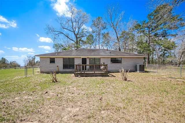 rear view of property featuring a deck, a yard, and a gate