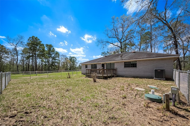 rear view of house with brick siding, a lawn, a wooden deck, and a fenced backyard