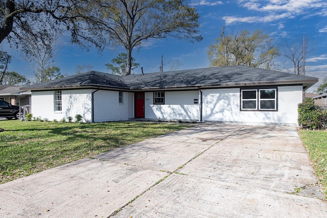 single story home with concrete driveway and a front yard