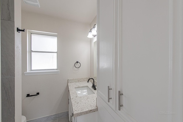 bathroom with vanity, toilet, and visible vents