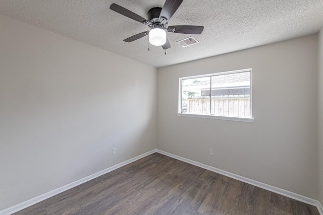 empty room with visible vents, baseboards, dark wood-style floors, a textured ceiling, and a ceiling fan