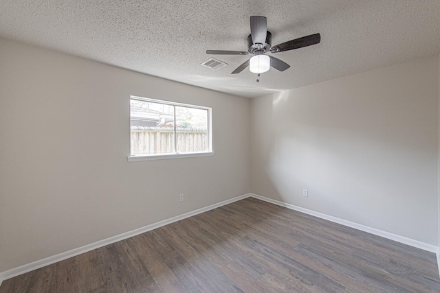 empty room with visible vents, a textured ceiling, baseboards, ceiling fan, and dark wood-style flooring