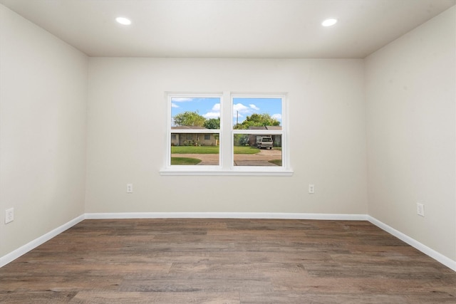 spare room featuring recessed lighting, wood finished floors, and baseboards