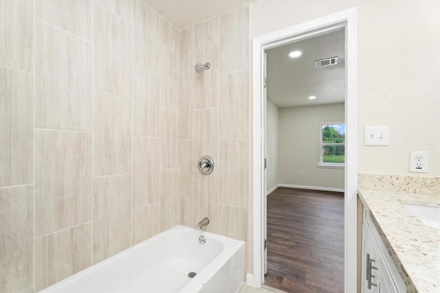 full bath featuring visible vents, baseboards, shower / bathtub combination, wood finished floors, and vanity