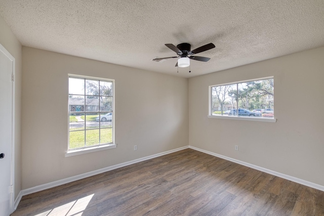 unfurnished room with baseboards, a healthy amount of sunlight, and dark wood-style flooring