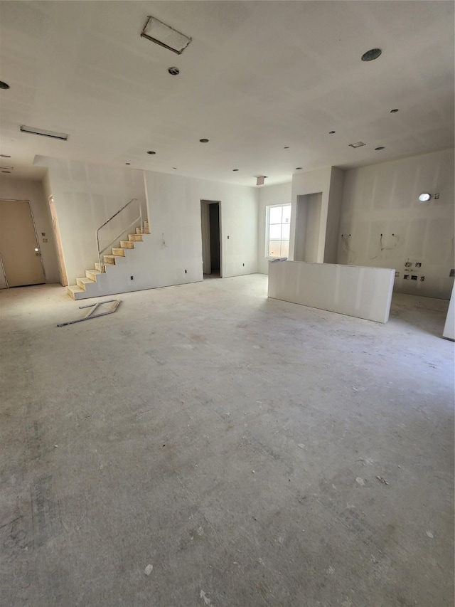 unfurnished living room with stairs