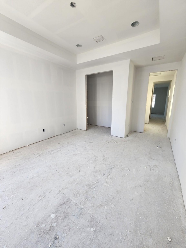 unfurnished bedroom with a raised ceiling