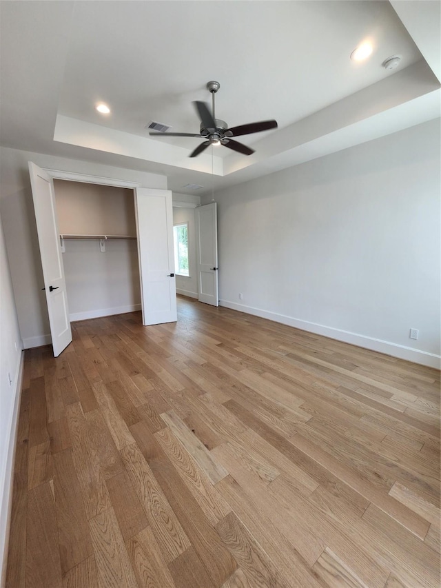 407 Forest Reserve Pl, Houston, TX 77079 - unfurnished bedroom featuring a raised ceiling, light wood-style flooring, baseboards, a closet, and recessed lighting