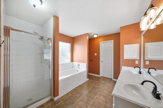 full bathroom with tile patterned flooring, a bath, and a sink