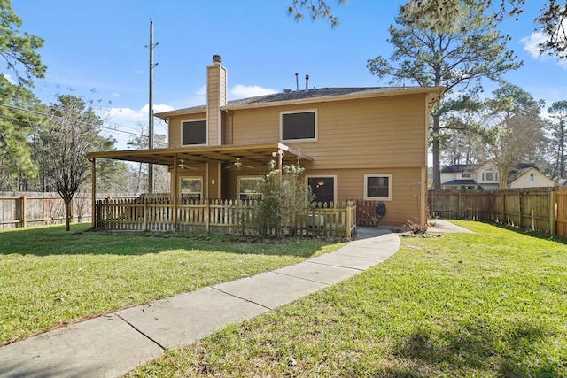 view of front of home featuring a front lawn, a fenced backyard, a chimney, and ceiling fan