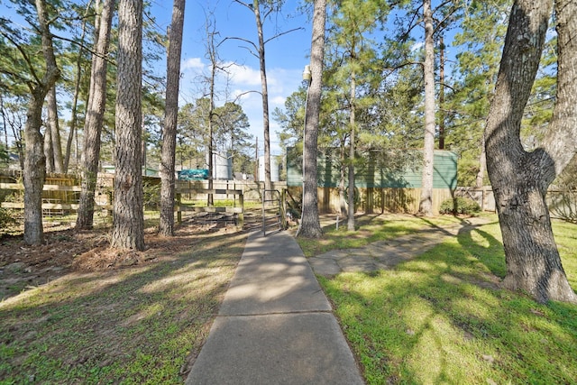 view of home's community with a yard and fence