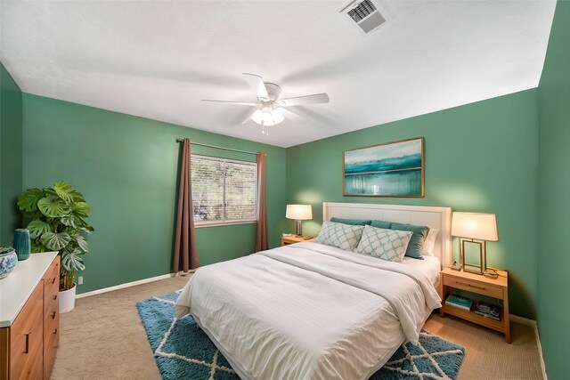 bedroom with light colored carpet, baseboards, visible vents, and a ceiling fan