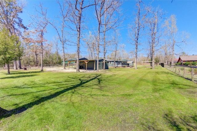 view of yard featuring an outdoor structure and fence