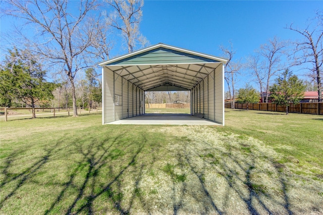 view of outbuilding featuring a detached carport, fence, and driveway