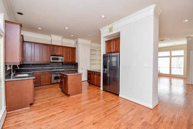 kitchen featuring appliances with stainless steel finishes, visible vents, ornamental molding, and a sink