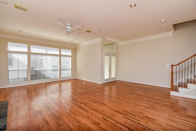 unfurnished living room with light wood finished floors, crown molding, stairs, and baseboards