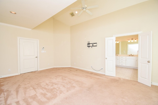 unfurnished room with visible vents, high vaulted ceiling, a ceiling fan, baseboards, and light colored carpet