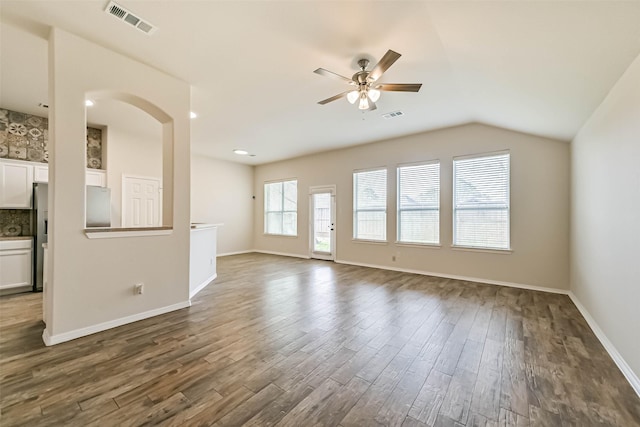 unfurnished living room featuring visible vents, baseboards, a ceiling fan, and dark wood-style flooring