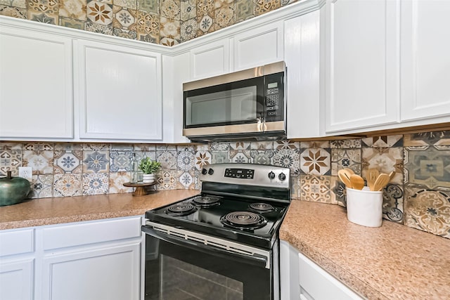 kitchen featuring decorative backsplash, light countertops, white cabinets, electric stove, and stainless steel microwave