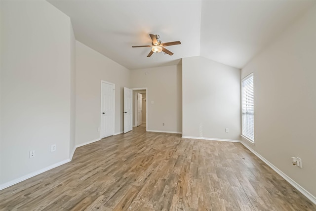 empty room with vaulted ceiling, a ceiling fan, baseboards, and light wood finished floors